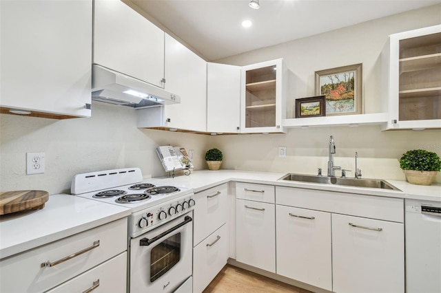 kitchen with light wood-type flooring, white appliances, white cabinetry, and sink