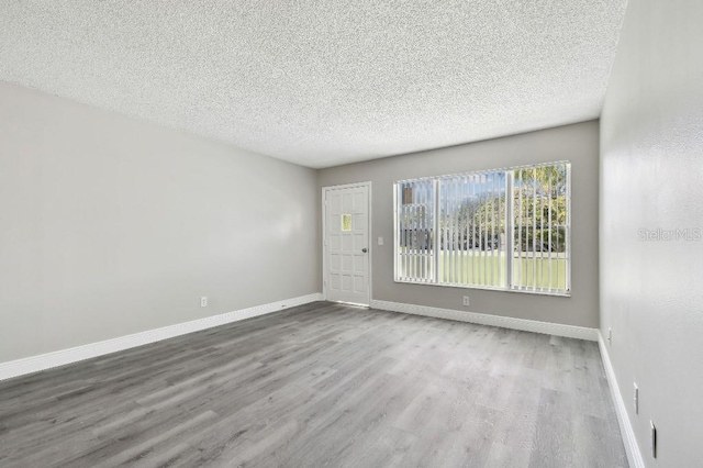 spare room featuring wood-type flooring and a textured ceiling