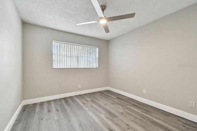 spare room featuring light wood-type flooring, a textured ceiling, and ceiling fan