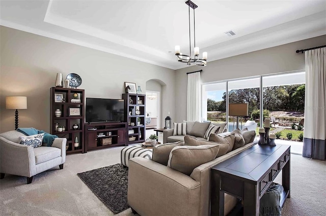 carpeted living room with an inviting chandelier