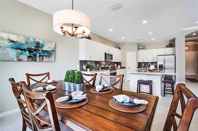 tiled dining room featuring sink and an inviting chandelier