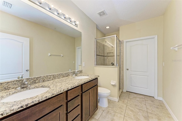 bathroom featuring tile patterned flooring, toilet, walk in shower, and a textured ceiling