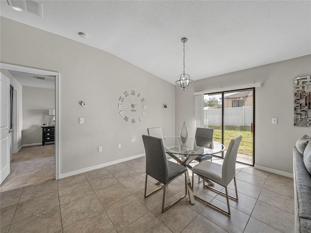 dining area featuring a chandelier, a textured ceiling, tile patterned floors, and lofted ceiling