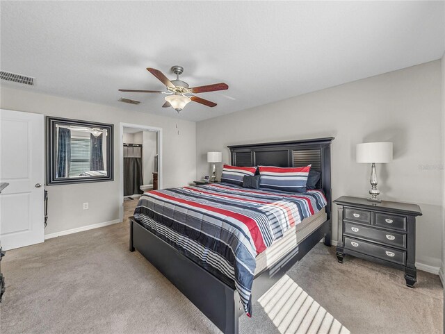 bedroom with carpet, ensuite bathroom, and ceiling fan