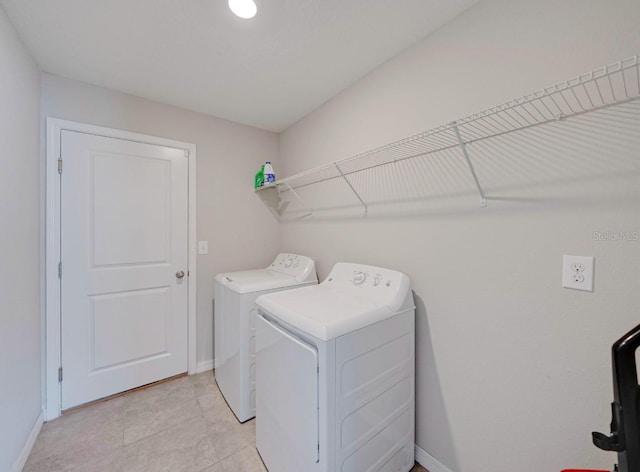 clothes washing area featuring separate washer and dryer and light tile patterned floors