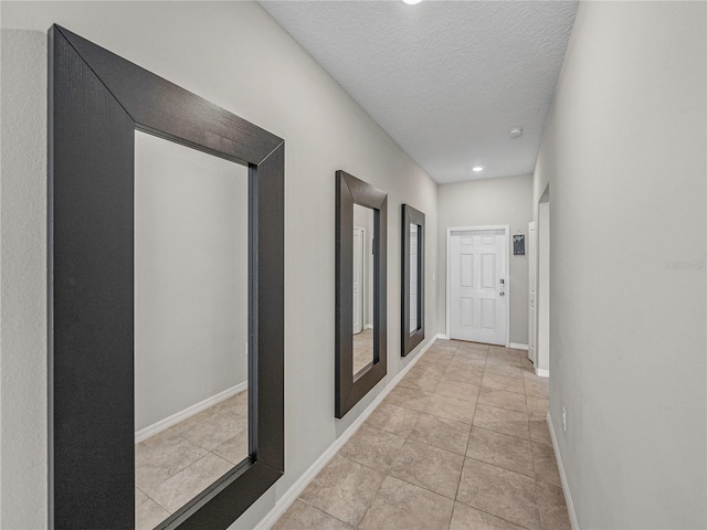 hallway featuring light tile patterned floors and a textured ceiling