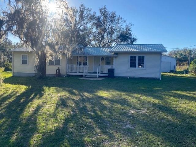 rear view of property with a porch and a lawn