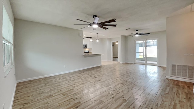 unfurnished living room with ceiling fan and light wood-type flooring