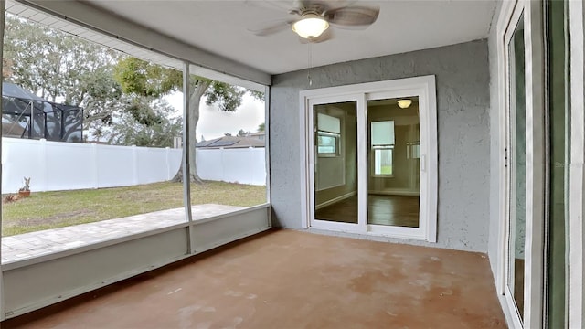 unfurnished sunroom with ceiling fan