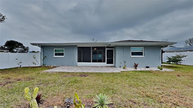 back of property featuring a sunroom, a yard, and a patio