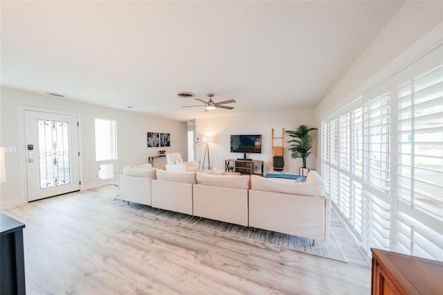 living room with light hardwood / wood-style flooring, plenty of natural light, and ceiling fan