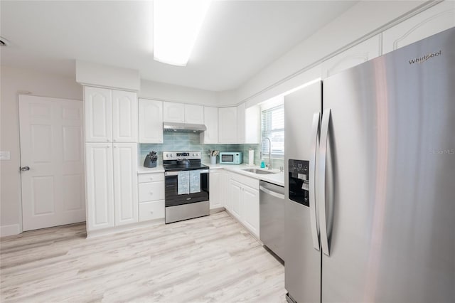 kitchen featuring white cabinets, light wood-type flooring, sink, and appliances with stainless steel finishes