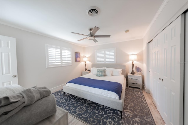 bedroom with ceiling fan, crown molding, light hardwood / wood-style flooring, and multiple windows