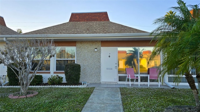 doorway to property with a lawn