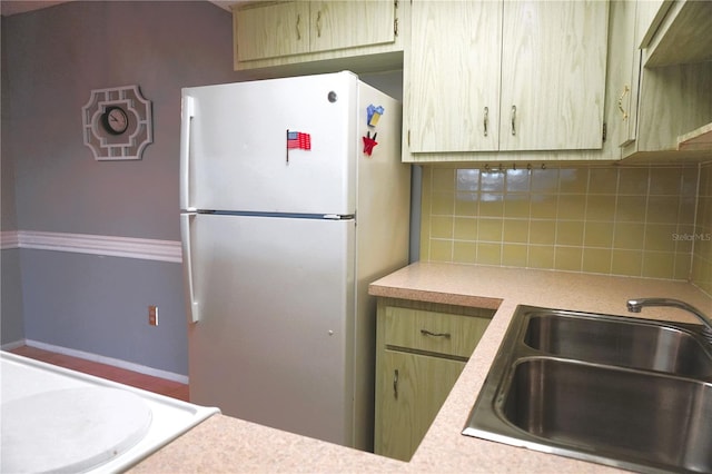 kitchen with sink, light brown cabinets, white fridge, extractor fan, and decorative backsplash