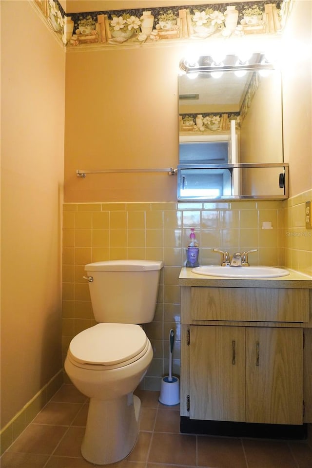 bathroom with tile patterned floors, vanity, toilet, and tile walls