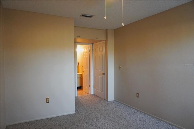 spare room with a textured ceiling and light colored carpet