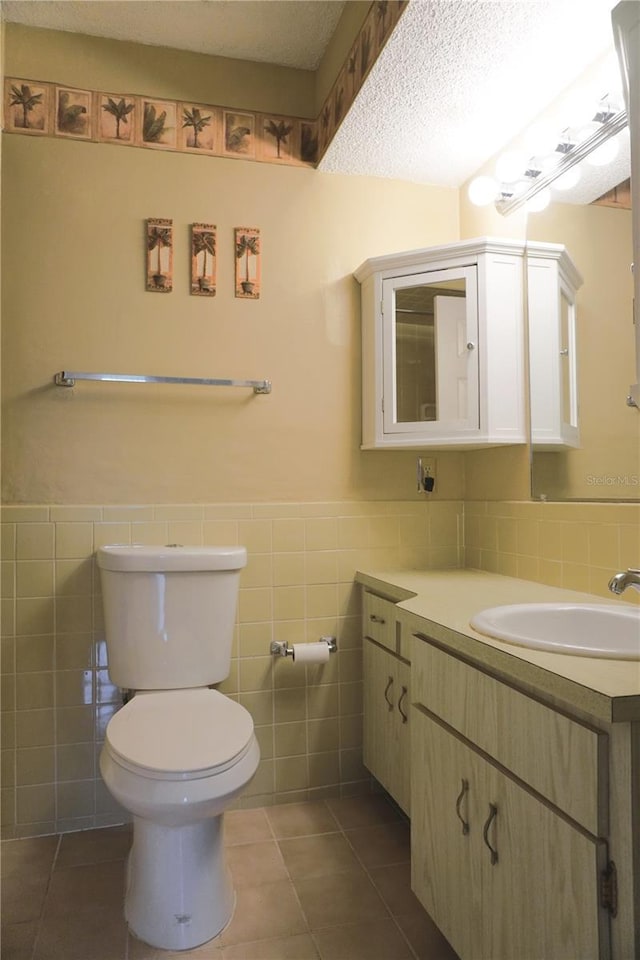 bathroom with tile patterned flooring, a textured ceiling, and tile walls