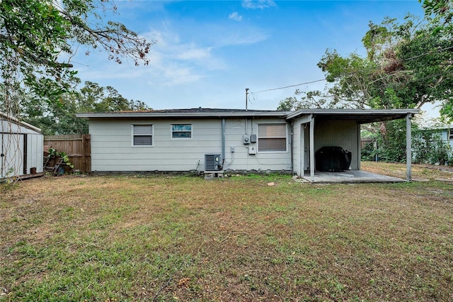 back of house featuring a lawn, central AC, and a shed