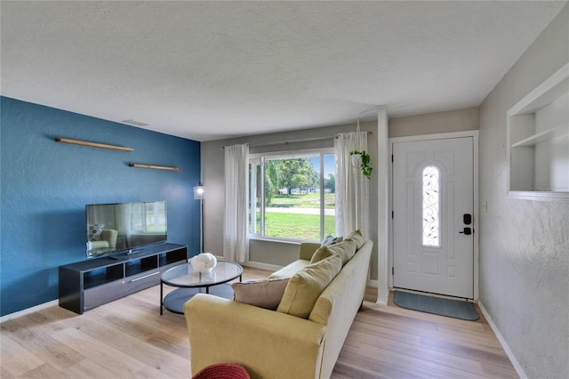 6524 14th St N, Saint Petersburg, FL 33702 - living area featuring a textured wall, wood finished floors, a textured ceiling, built in shelves, and baseboards