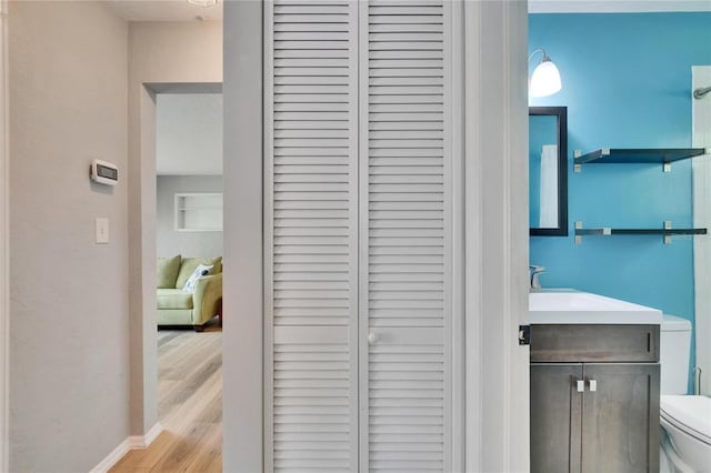 6524 14th St N, Saint Petersburg, FL 33702 - bathroom with a closet, toilet, wood finished floors, vanity, and baseboards