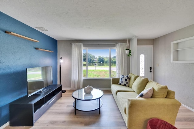 6524 14th St N, Saint Petersburg, FL 33702 - living area with a textured wall, wood finished floors, a textured ceiling, and baseboards
