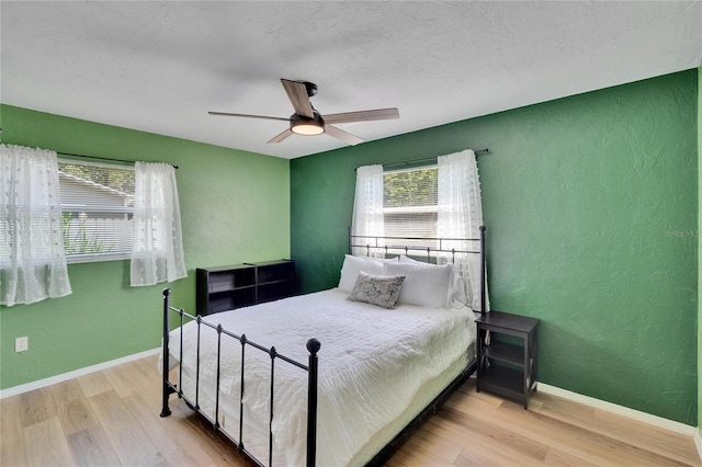 6524 14th St N, Saint Petersburg, FL 33702 - bedroom featuring wood finished floors, a textured wall, baseboards, and a ceiling fan