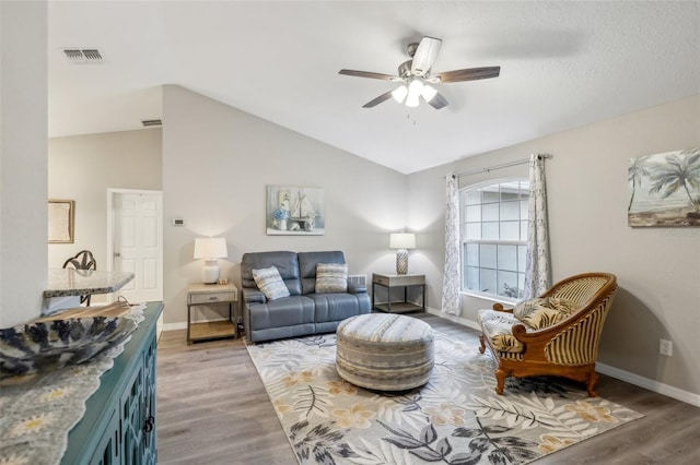 living room with light hardwood / wood-style floors, lofted ceiling, and ceiling fan