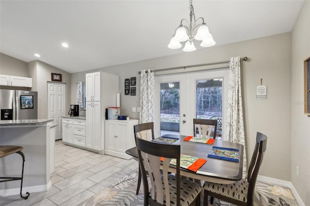 dining space with vaulted ceiling, french doors, and a notable chandelier