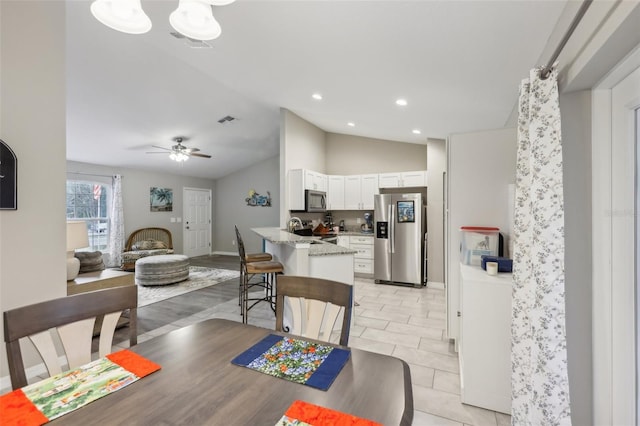 dining area featuring vaulted ceiling, ceiling fan, and light tile patterned floors