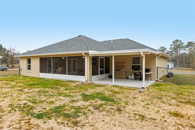 rear view of property with a yard, a patio area, and a sunroom