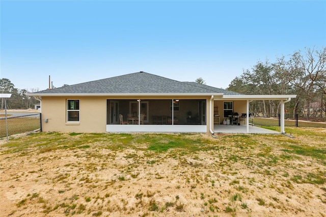 rear view of property featuring a patio area, a lawn, and a sunroom