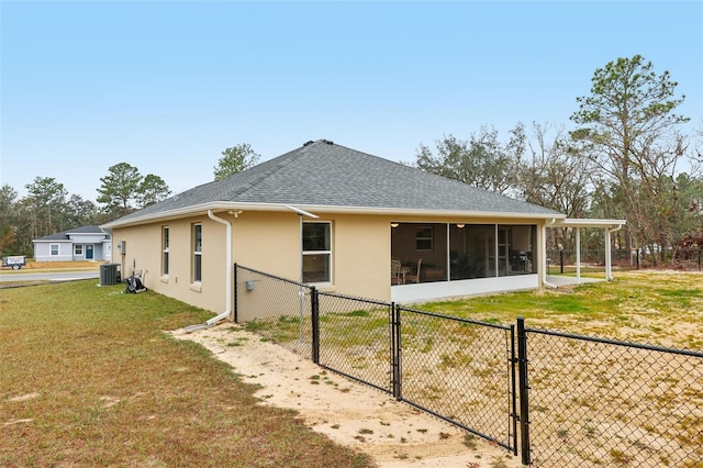 rear view of property with a yard, a sunroom, and central air condition unit