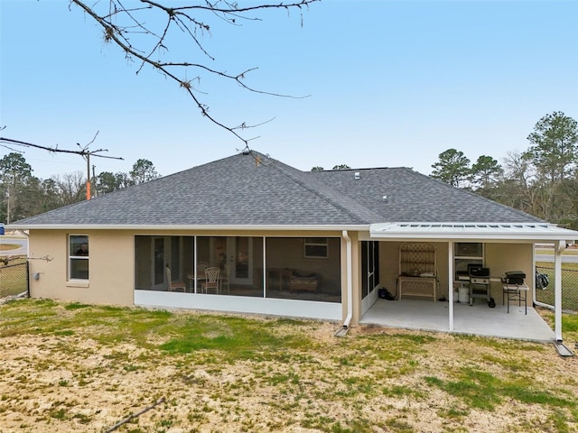 rear view of property with a yard, a patio, and a sunroom