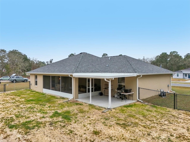 rear view of house with a yard, a sunroom, and a patio area