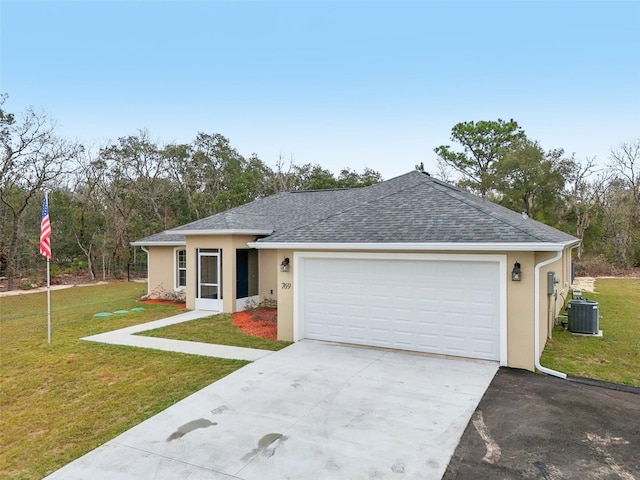 ranch-style home featuring cooling unit, a garage, and a front lawn