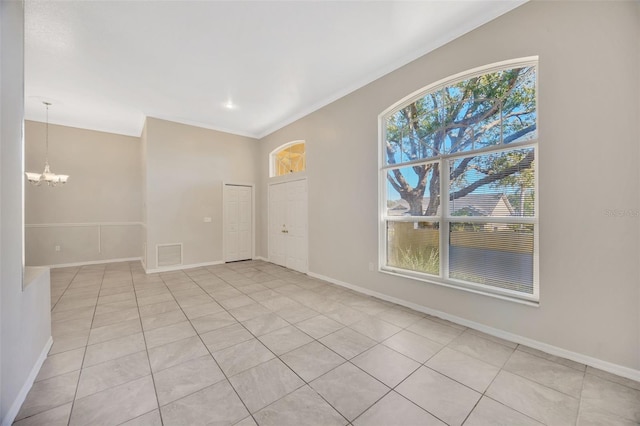 unfurnished room with light tile patterned floors, ornamental molding, and an inviting chandelier