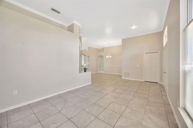 unfurnished room with a notable chandelier, plenty of natural light, crown molding, and light tile patterned flooring