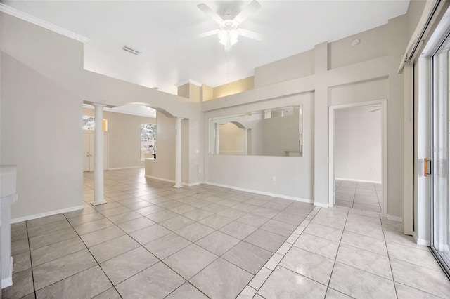 unfurnished room featuring ceiling fan, light tile patterned flooring, ornate columns, and a wealth of natural light