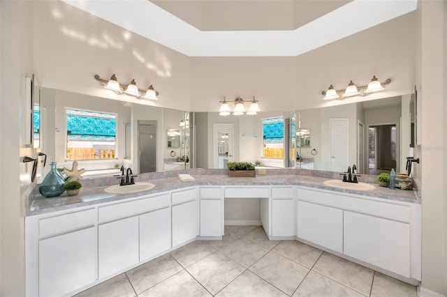 bathroom featuring a towering ceiling, tile patterned flooring, and vanity