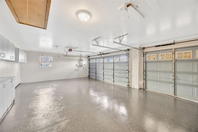 garage featuring electric panel and a garage door opener