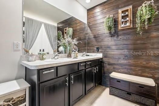 bathroom with vanity and wooden walls