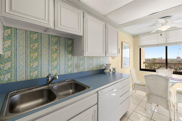 kitchen featuring white dishwasher, ceiling fan, sink, light tile patterned floors, and white cabinets