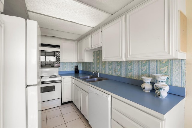 kitchen featuring white cabinets, white appliances, light tile patterned flooring, and sink