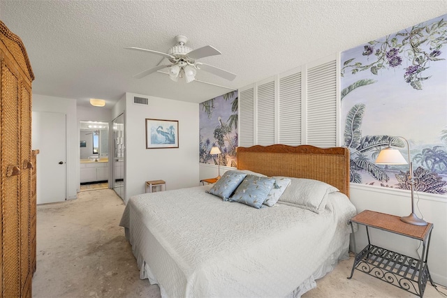 bedroom featuring ensuite bathroom, ceiling fan, and a textured ceiling