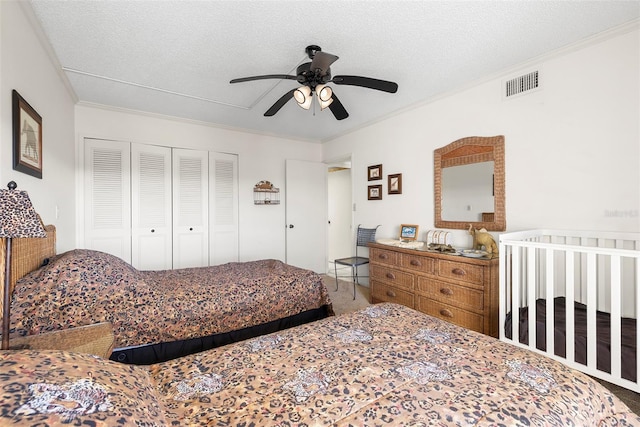 bedroom with ceiling fan, a closet, crown molding, and a textured ceiling