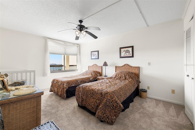 carpeted bedroom with ceiling fan, a textured ceiling, and a closet