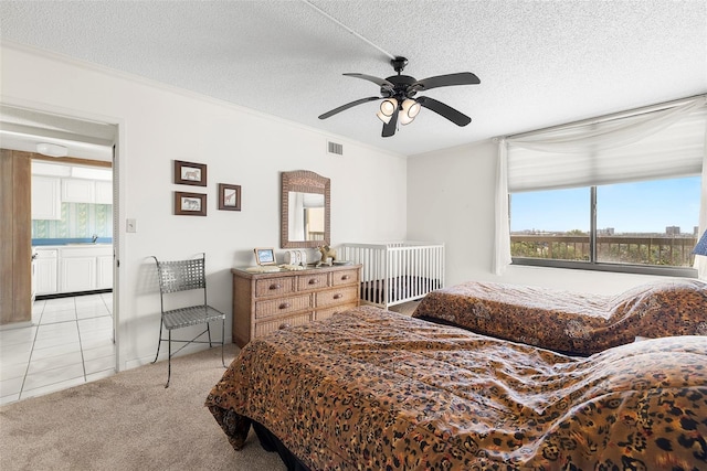 carpeted bedroom with multiple windows, ceiling fan, and a textured ceiling