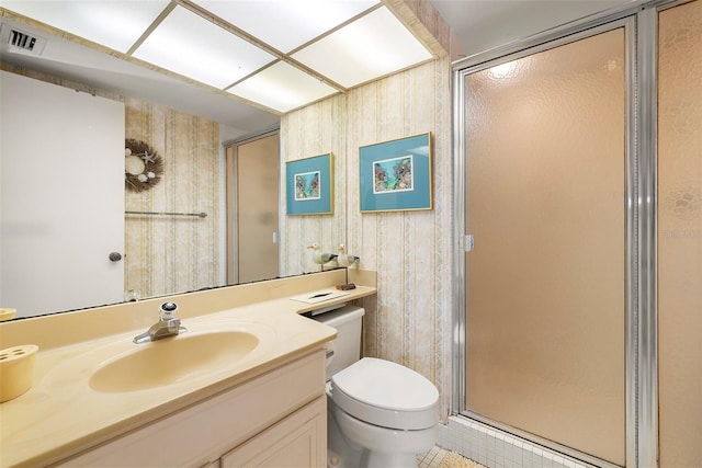 bathroom with tile patterned floors, vanity, a shower with door, wooden walls, and toilet