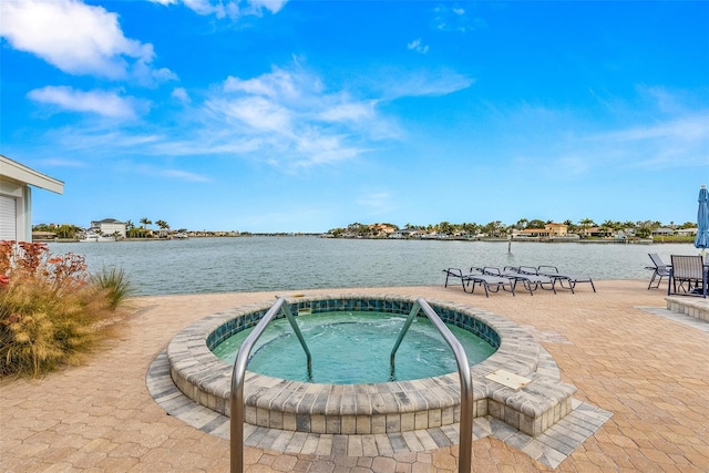 view of swimming pool with a patio area, a community hot tub, and a water view